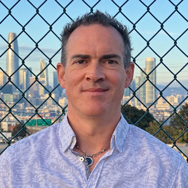 Justin, smiling, with the San Francisco skyline behind him